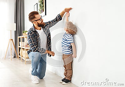 Concept of development, growing up. father measures height of his young child son Stock Photo