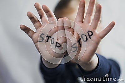 Concept of domestic violence and child abusement. A little girl shows her hand with the word STOP written on it. Children violence Stock Photo