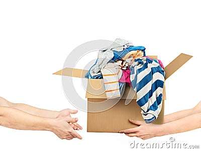 The concept of donating. Hands are giving a box of clothes to other hands Stock Photo