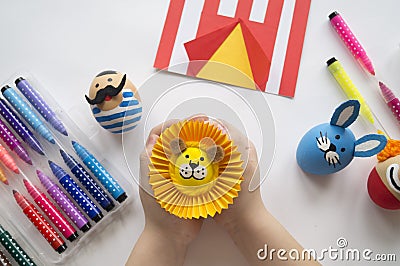 The concept of Easter with cute and cheerful handmade eggs, a rabbit, a clown, a strongman and a lion. Stock Photo