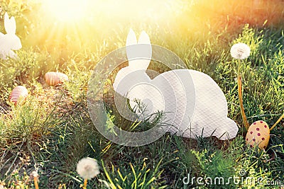 The concept of Easter holidays. Decorative handicraft handmade product in the form of a lying white rabbit, located next to the Stock Photo