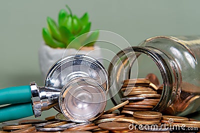 The concept of economy and medicine costs health. Pile of real coins and stethoscope Stock Photo