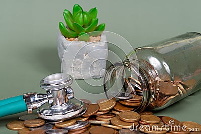 The concept of economy and medicine costs health. Pile of real coins and stethoscope Stock Photo