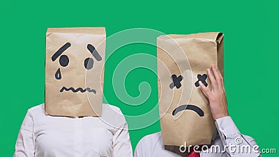 Concept of emotions, gestures. a couple of people with bags on their heads, with a painted emoticon, sad, crying, tired Stock Photo