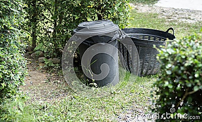 Concept of environment preservation, black plastic recycle bins placed in the garden for cleanness Stock Photo