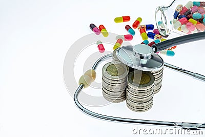 Concept of expensive healthcare with coins, stethoscope and pill Stock Photo