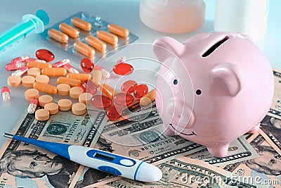 The concept is expensive medetsina.Next to the piggy bank are pills, money and a thermometer. Stock Photo