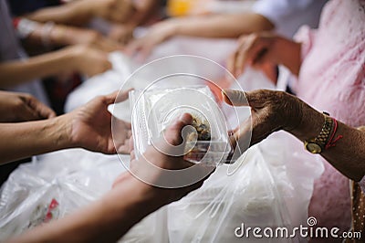 The concept of feeding : The hands of the poor receive food from the hands of the humane : Helping Feed the Poor Stock Photo