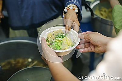 The concept of feeding : The hands of the poor receive food from the hands of the humane : Helping Feed the Poor Stock Photo