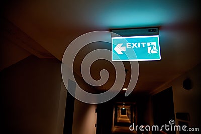 Concept of fire safety. Glowing pointer escape door in the dark corridor. Stock Photo