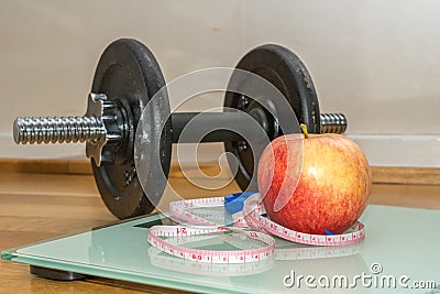 Concept - Getting in Shape, Measuring Tape, Apple, Scale and Dumbbell Stock Photo