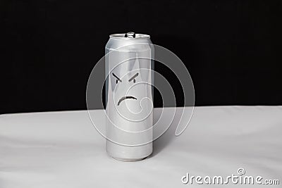 The concept of grumpy man. Angry emoticon on aluminium can, Emoji with rageful face. On black background Stock Photo