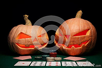 The concept of Halloween. Evil scary pumpkins play poker. Jack L Stock Photo