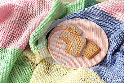 Concept happy colorful still life. Biscuit or cookies with knitted effect on colorful pastel plaid Stock Photo