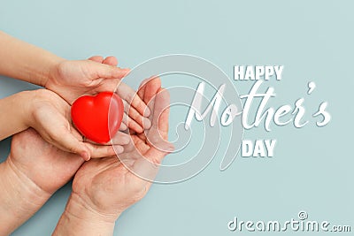 Concept Happy Mother`s Day or International Day of Families.Happy women`s day.Heart in the hands of daughter and mother on a blu Stock Photo