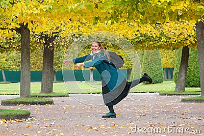 The concept of haste and tardiness. A woman is fooling around and having fun in the Park, against the background of yellow trees Stock Photo