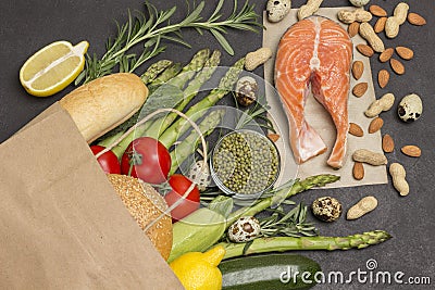 Concept of healthy eating and longevity. Food sources of omega 3, protein. Paper bag with salmon leavy vegetables, beans nuts, Stock Photo