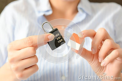 The concept of home security or insurance with cipher lock held aside from a miniature house Stock Photo