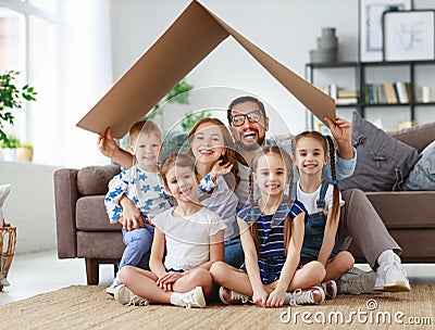 Concept of housing and relocation. happy big family mother father and kids with roof at home Stock Photo