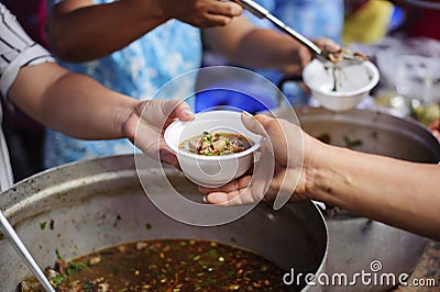 The concept of humanitarianism : The hands of refugees have been aided by charity food to alleviate hunger : Feeding Concepts : Stock Photo