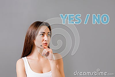 Concept of idea and information search. Portrait of a thoughtful young Caucasian woman. Gray background. Copy space. The Stock Photo