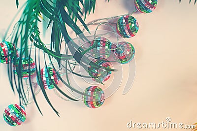 Concept image of tropical winter holidays with felt christmas tree palm leaf and illumination lights Stock Photo