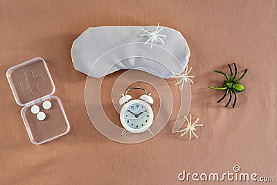 Concept of insomnia and nightmare disorder, flat lay. Sleeping mask, alarm clock and spiders. Unhealthy sleep Stock Photo