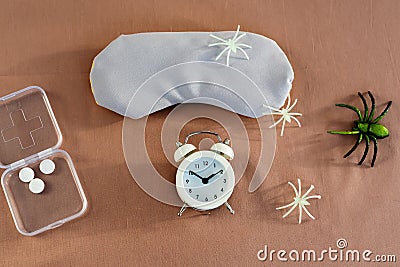 Concept of insomnia and nightmare disorder, flat lay. Sleeping mask, alarm clock and spiders. Unhealthy sleep Stock Photo