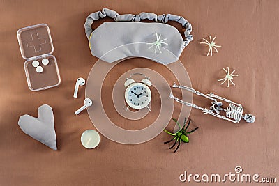 Concept of insomnia and nightmare disorder, flat lay. Sleeping mask, alarm clock and spiders. Unhealthy sleep Stock Photo