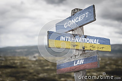 concept international law text quote on wooden signpost outdoors on nato colored flag, ukrainian flag and russian flags Stock Photo