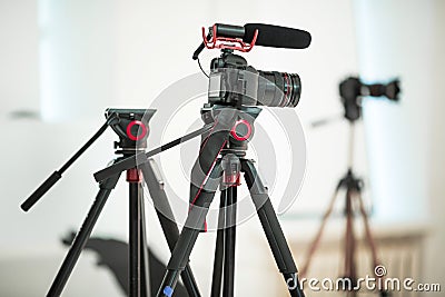 Concept interview, digital camera on a tripod with a microphone in the studio on a white background Stock Photo