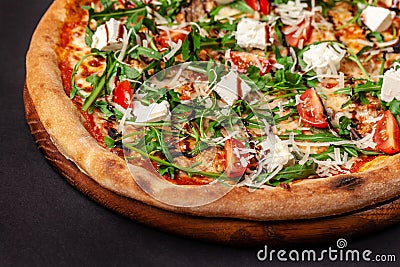 The concept of Italian cuisine. Real Italian pizza on a thin cake with large sides on a black background. Close up Stock Photo