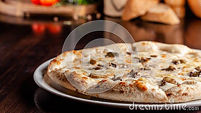 The concept of Italian cuisine. Thin cheese pizza with mushrooms, with large sides of Semola flour Stock Photo