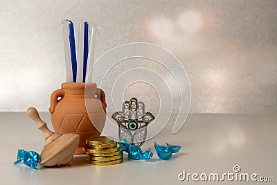 Concept of of jewish religion holiday hanukkah with wooden spinning top toy dreidel, hamsa, candles and chocolate coins over Stock Photo