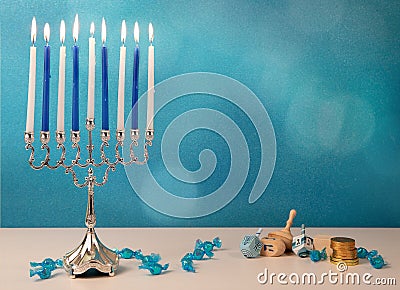 concept of jewish religious holiday hanukkah with wooden spinning top toys & x28;dreidel& x29;, traditional chandelier menorah and Stock Photo