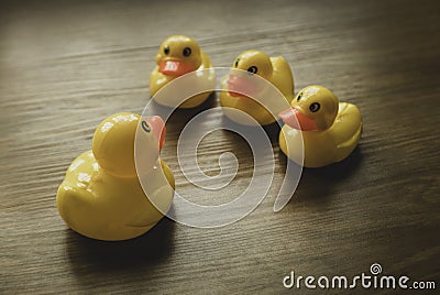 Concept of leader and follower. Selective focus of a small toy duck and big duck having some discussion on wooden background Stock Photo