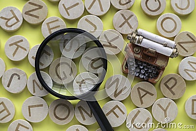 Concept of learning english, searching for word, and information. English alphabet letter and magnifying glass on yellow backgroun Stock Photo