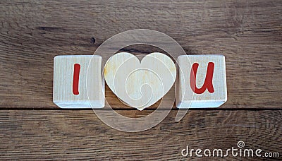 Concept letters I and U made on wooden blocks. Wooden heart Stock Photo
