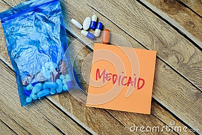 Concept of Medicaid write on paperwork isolated on Wooden Table Stock Photo