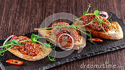 The concept of Mexican cuisine. Beef tartare with parsley, French mustard beans on baguette croutons. A dish in the restaurant Stock Photo
