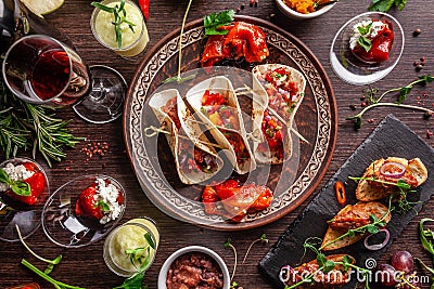 The concept of Mexican cuisine. Mexican food and snacks on a wooden table. Taco, sorbet, tartar, glass and bottle of red wine. Stock Photo