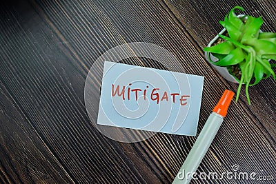 Concept of Mitigate write on sticky notes isolated on Wooden Table Stock Photo