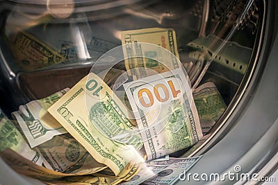 The concept of not legal money-laundering. Many banknotes are inside Washer. A lot of cash dollars is washed in the drum of a Stock Photo