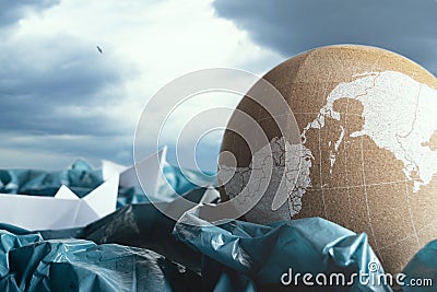 Concept of ocean pollution with plastic. Paper boats and cork globe in stormy sea made of plastic bags. Creative representation of Stock Photo