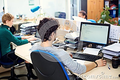 The concept of office work. Rear view man working at a comput Stock Photo