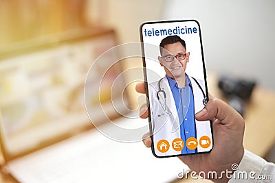 Concept of online medical services, shows smartphone app with Asian male doctor smiling, telehealth, telemedicine video call Stock Photo