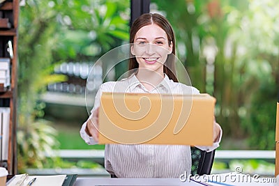 Concept of parcel delivery and selling online,Retailer holding parcel box prepare to send the product to the customer and smile Stock Photo