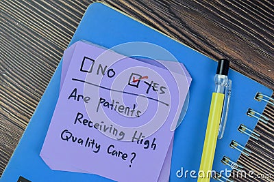 Concept of Are patients Receiving high Quality Care? Yes write on sticky notes isolated on Wooden Table Stock Photo