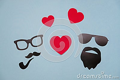 Concept photo of homosexuality: male masks with hearts on blue background Stock Photo