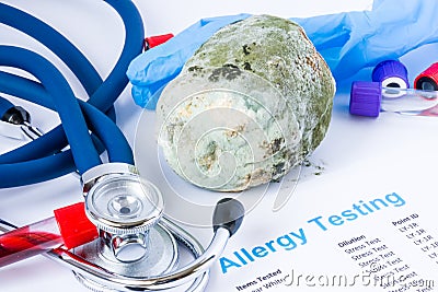 Concept photo of mold or mildew allergy testing. Fruit covered with mold, is near the test tubes with blood sample for tests, ste Stock Photo